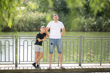 Father and son walking outdoors in summer on the street