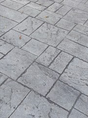 Angled view of cement floor, tile texture, suitable for use as grungy, abstract background for graphics and text