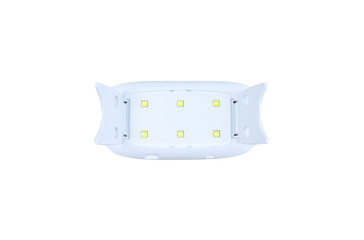 Beauty gadget for manicure and pedicure. UV lamp with light for drying nails with gel polish. Home life during quarantine, coronavirus pandemic, self-isolation.