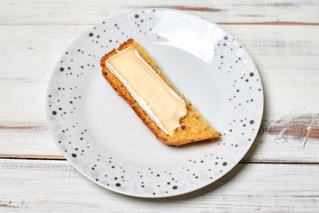 Bread with brie cheese on a plate on a wooden background.