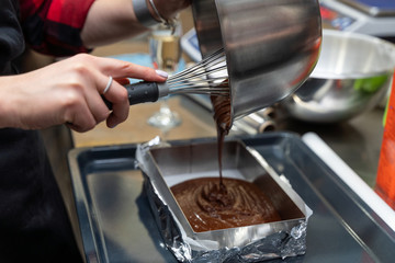 Woman pouring chocolate batter into a pan