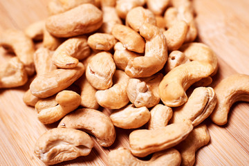 Raw cashew nuts close-up on a light wooden background.