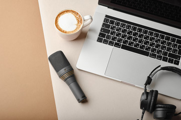 Flat lay composition with Microphone for podcasts  and black studio headphones on brown background with coffee and laptop, learning online education concept.