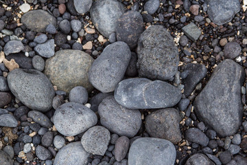 Gray pebbles stones on the shore close up view from above
