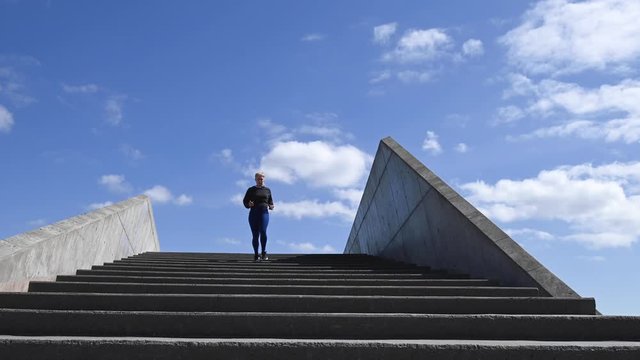 Attractive young woman, running down stairs in real time, stock footage by Brian Holm Nielsen