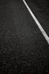 Fototapeta premium Black solid asphalt with a white stripe