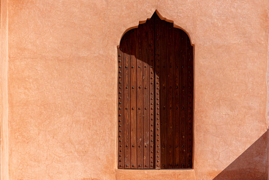 Traditional Arabian architecture, muslim style wooden door and red clay wall