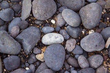 Gray pebbles stones on the shore close up view from above