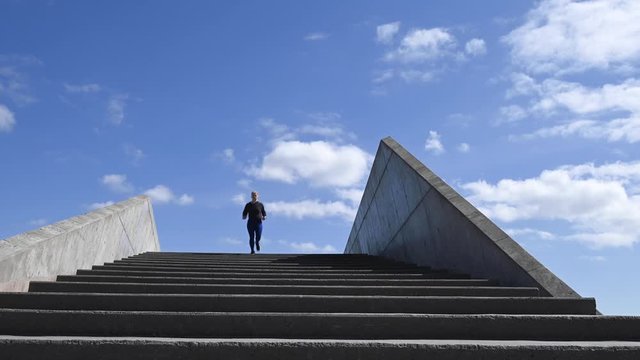 Attractive young woman, running down stairs in slow motion, stock footage by Brian Holm Nielsen