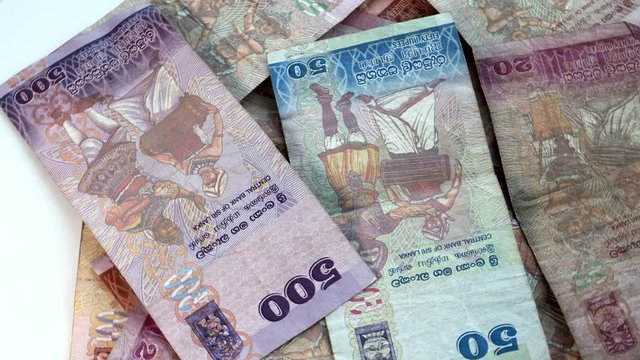 Sri Lankan money. Colored banknotes closeup rotation.