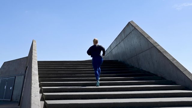 Attractive young woman, running up stairs in slow motion, stock footage by Brian Holm Nielsen