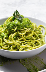 Spaghetti with homemade pesto sauce on gray background