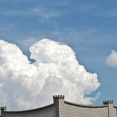 white clouds over the roof of the house