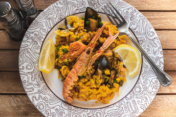 Top view of seafood traditional Spanish paella rice dish with lemon and mussels