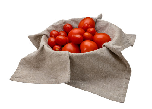 Frische Tomaten in einem Korb mit einem beigen Leinentuch.