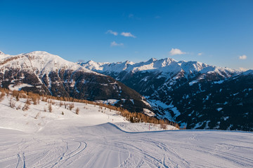 January 2020 Sillian, Austria: snowy ski run on the foreground, blue sky on the background