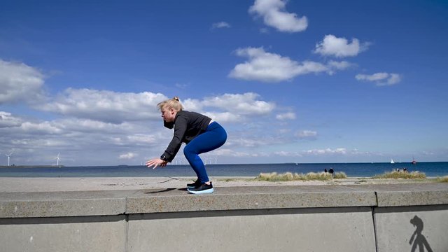Attractive, fit, young woman doing burpees in slow motion, stock footage by Brian Holm Nielsen