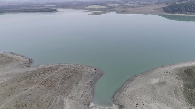 AERIAL DRONE TILT UP DISCOVERING DRY ARID RESERVOIR