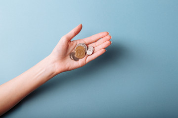 Woman's hands holding a heap of coins background, top view, with copy space
