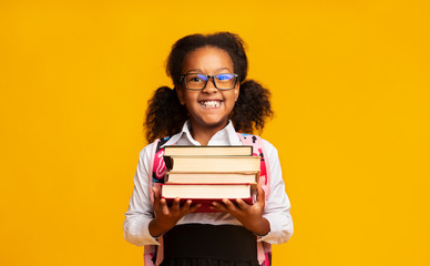 Elementary School Girl Holding Books Posing, Studio Shot