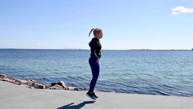 Attractive, fit, young woman jumping rope in slow motion, stock footage by Brian Holm Nielsen