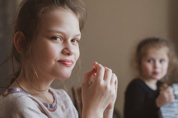 Two girls have breakfast in the morning in the kitchen at home