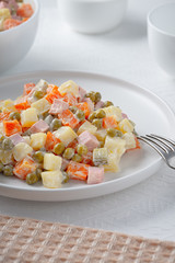 Russian traditional salad Olivier with vegetables and meat.