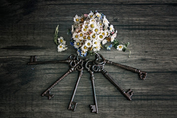 Vintage keys and bouquet of wild flowers in vase