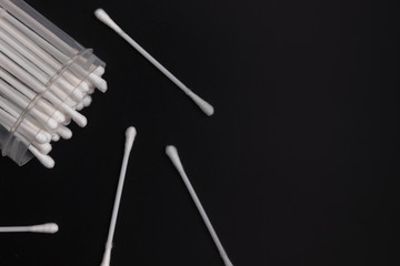 A pot of swabs placed on a dark surface. Hygiene article on people.