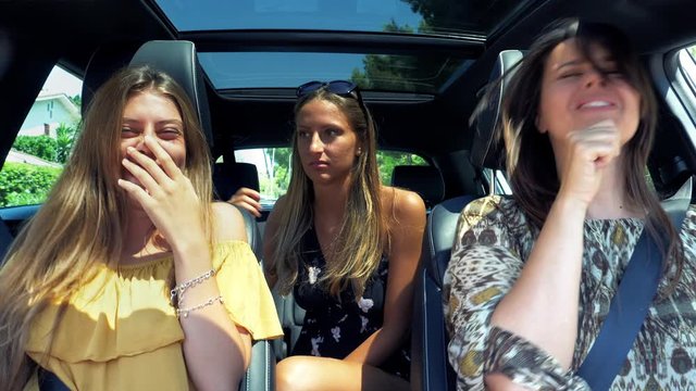 Female teenagers looking mother singing in car funny making faces end of quarantine joy