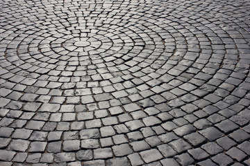 Brick cobblestone pavement pattern rocky pathway close up background. Empty dark stone street pavement, abstract gray cobblestone paved road pattern with no people