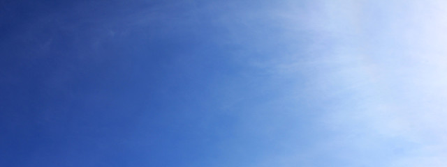 Blue sky background with light white cloudy texture. Cloudscape nature background on sunny day, blue color sky horizon view with sunshine rays on warm summer day