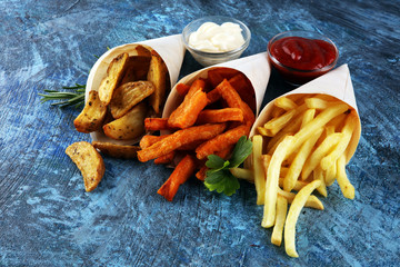 Variety of potatoes with fries. potato wedges, french fries, sweet potato for lunch on table