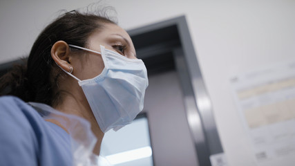 Nurse looking in mirror and preparing for a day in the ER during corona virus pandemic