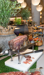 Jamon serrano spanish raw smoked ham in a slicing machine, during brunch buffet