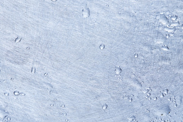 liquid droplets on silver colored metal surface. background backdrop. soft focus.