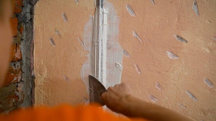 Plasterer putting plaster on wall. Putting plaster on the wall. Stucco between the holes.