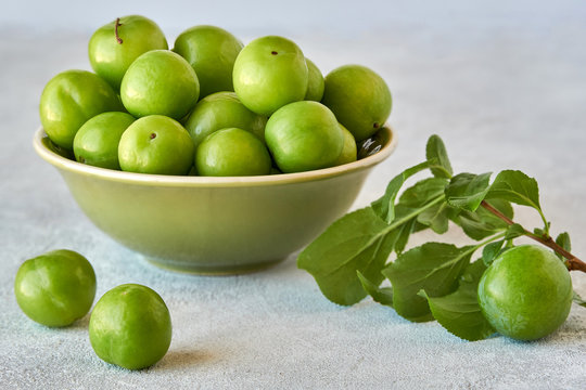 Green sour plum in ceramic bowl