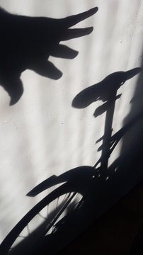 A shadow of the hand reaches for the bike in the entrance. Concept of bicycle thefts, cycling