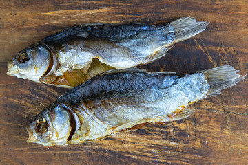 Dried salted crucian fishes on wooden background. Snack to beer