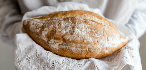 Banner.Whole wheat bread in hands.Homemade freshly baked bread.Healthy food.Close-up view