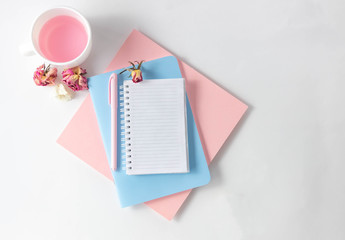 Female workspace with empty open notebook for writing, pen on a white table. Top view, flat lay, copy space, minimalism