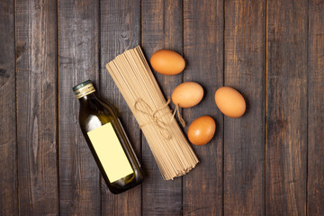 Cooking. Eggs, pasta and olive oil on a wooden table.