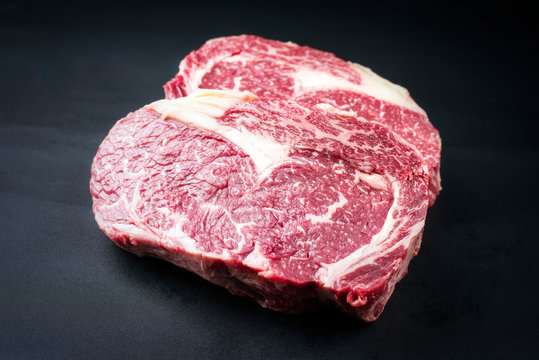 Rohes dry aged Wagyu Entrecote Steak vom Rind als closeup auf schwarzen Hintergrund mit Textfreiraum 