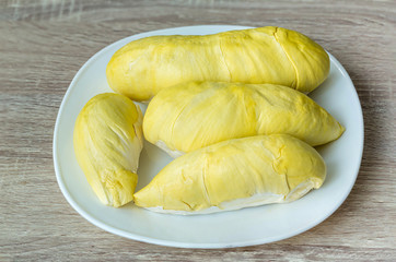 Fresh durian fruit placed on a white plate. Durian the king of fruits The yellow color is on the white plate. Ripe durian tropical fruit summer for sweet dessert or snack in Thailand 