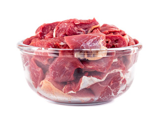 Pieces of fresh beef in a glass bowl isolated on white background