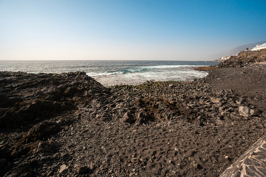 Black Volcanic Sand On The Beach