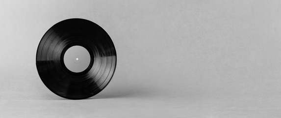 Black LP vinyl record isolated on abstract gray background with wide copy space