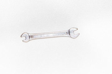 Wrench isolated on bright white background with silver color, top view