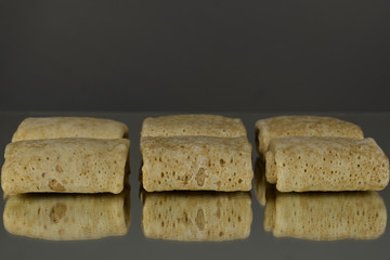 Semi-finished products. Filled Frozen Pancakes. On a mirror background. Isolates.